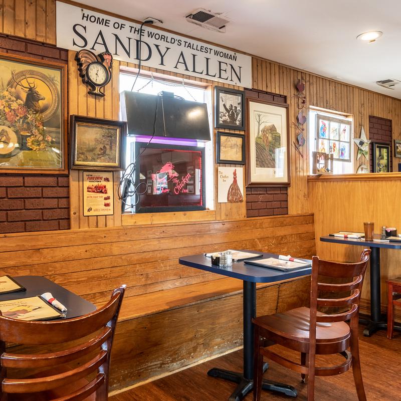 Chicken Inn dining room with wood paneling and the Home of the World's Tallest Woman, Sandy Allen sign